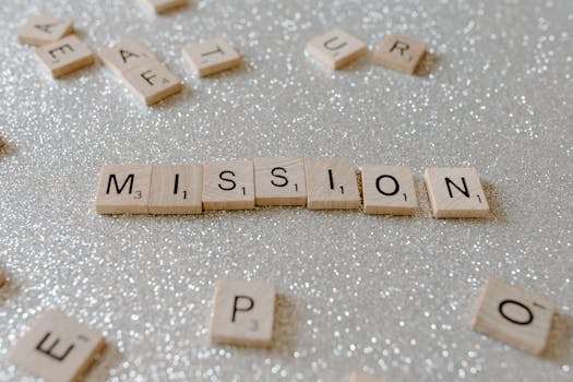 Scrabble tiles spelling 'Mission' on a sparkling surface convey determination and goals.